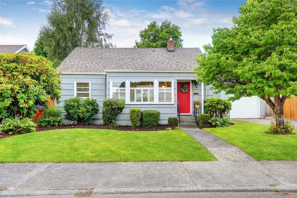 Exterior of small American house with blue paint; The Rise of Smaller Homes and Smaller Lots